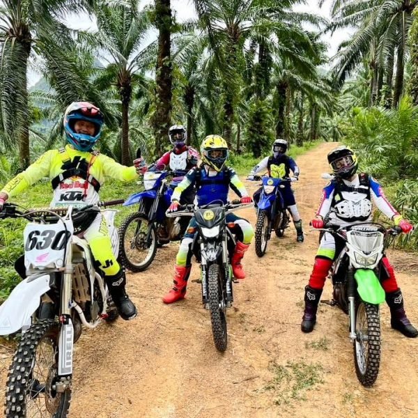 Guided off-road motorcycle tour group with dirt bikes in Krabi palm plantation